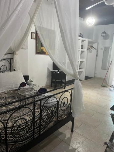 a bedroom with a bed with white curtains and a staircase at Studio S in Santa Teresa Gallura