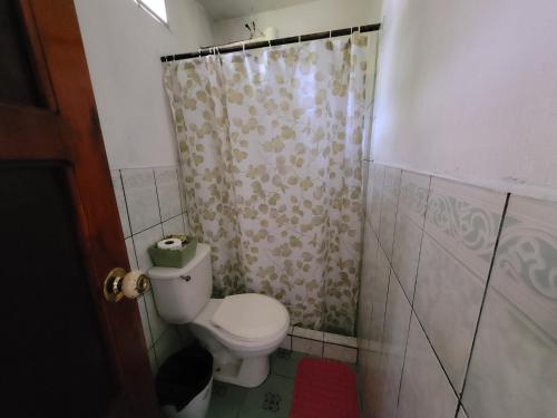 a bathroom with a toilet and a shower curtain at Hotel y Restaurante La Cabaña el Viajero in Castillo de San Felipe