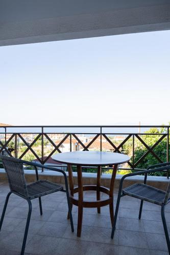 a table and chairs on a balcony with a view at Este Luxury Apartments in Kriopigi