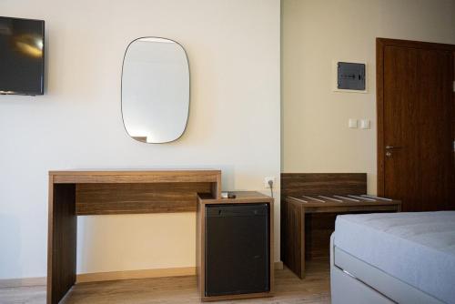a bedroom with a bed and a desk and a mirror at Este Luxury Apartments in Kriopigi