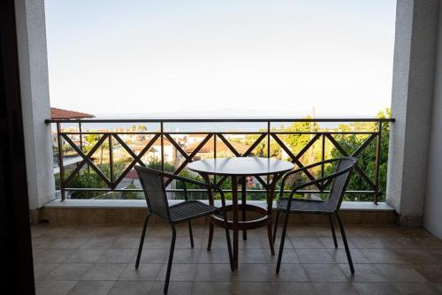 a table and chairs on a balcony with a view at Este Luxury Apartments in Kriopigi