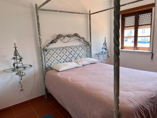 a bedroom with a bed with a metal bed frame at Casa das Dunas in Almograve