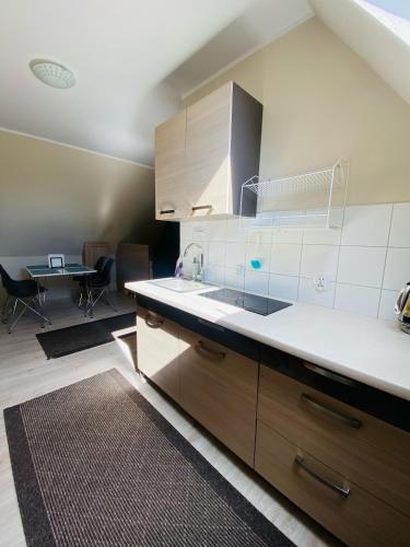 a kitchen with a sink and a table in a room at Apartamenty Złota Palma in Lądek-Zdrój