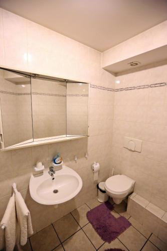a white bathroom with a sink and a toilet at Waldi Pokoje Gościne z aneksem in Karpacz