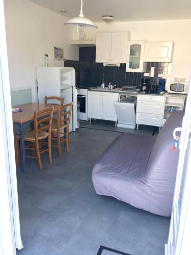 - une cuisine avec un canapé, une table et des chaises dans l'établissement Maison charmante avec jardin, Saint-Hilaire-de-Riez, proche mer, à Saint-Hilaire-de-Riez
