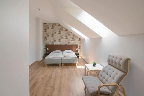 a bedroom with a bed and a chair at Vezezeris in Gaugariai