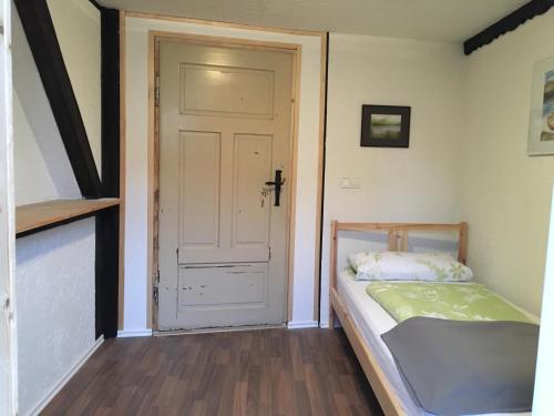 a small bedroom with a bed and a door at Ferienwohnung Vogelschar Urlaub auf dem Lebenshof in Kiebitz