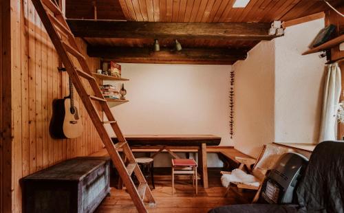 una habitación con una guitarra, una mesa y una escalera en Marko's eco cabin en Bled