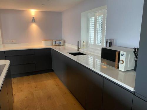 cocina con encimera y microondas en Contemporary living with amazing views. Pembrokeshire en Pembrokeshire