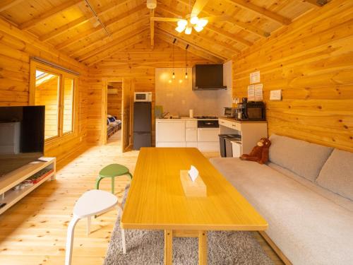 een woonkamer met een houten tafel en een keuken bij MELODIE HAUS - Vacation STAY 62790v in Nasu-yumoto