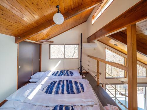 two beds in a room with wooden ceilings and windows at Baberu - Vacation STAY 13021 in Nasushiobara