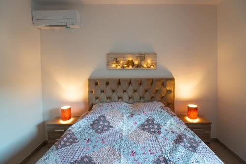 a bedroom with a bed with two candles on it at Superbe appartement à 2 pas des Halles, Climatisé, terrasse, garage in Narbonne