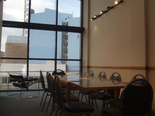 une table et des chaises dans une chambre avec une grande fenêtre dans l'établissement HOTEL SANTA CRUZ, à Río Gallegos