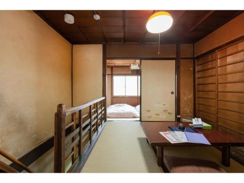 Zimmer mit einem Tisch und einem Bett in der Ferne in der Unterkunft Katsura Club - Vacation STAY 13032 in Kyoto
