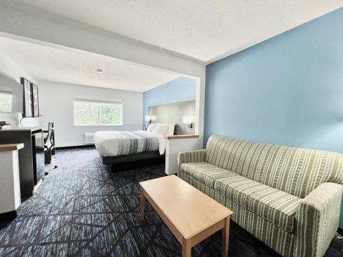 a hotel room with a bed and a couch at AmericInn by Wyndham Quincy in Quincy