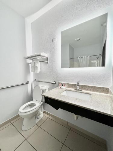 a bathroom with a toilet and a sink with a mirror at AmericInn by Wyndham Quincy in Quincy