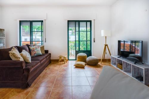 a living room with a couch and a tv at Santa Luzia in Alcácer do Sal