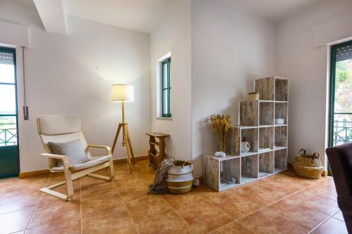 a living room with a chair and a table at Santa Luzia in Alcácer do Sal