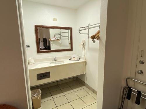 a bathroom with a sink and a mirror at Desert Sands Inn & Suites in Albuquerque