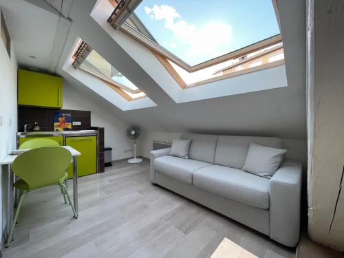 a living room with a couch and some skylights at Studio sous les toits Annecy Centre-Ville in Annecy