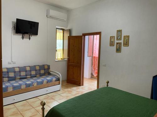 a bedroom with a couch and a television in a room at Appartamento ROSA in Lipari