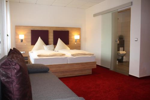 ein Hotelzimmer mit einem Bett und einem Bad in der Unterkunft Hotel Zum kühlen Grunde in Minden