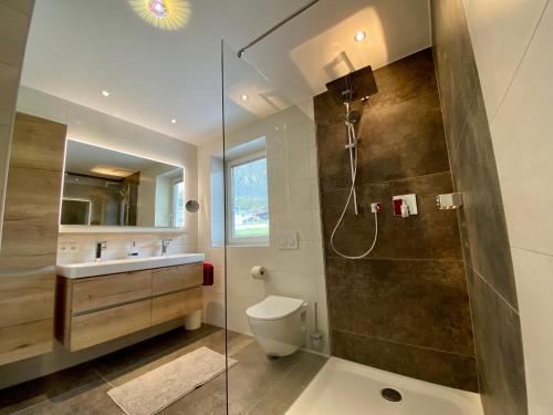 ein Bad mit einer Dusche, einem WC und einem Waschbecken in der Unterkunft Ferienhaus Alex in Wiesing