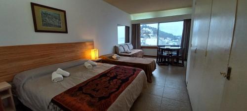 Habitación de hotel con cama y silla en El encanto del lago en San Carlos de Bariloche