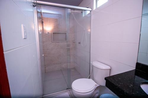 ein Bad mit einer Dusche, einem WC und einem Waschbecken in der Unterkunft Hotel Flor de Lotus in Santa Isabel do Pará