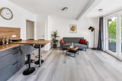 uma cozinha e sala de estar com uma secretária e um sofá em CityOase im Zentrum mit 24-7 Self Check-In, WLAN & Smart TV em Kiel