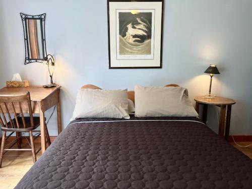 a bedroom with a bed and a table and a desk at L'Aubergine in Saint Hilarion