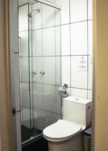 a bathroom with a toilet and a glass shower at OQ STANDARD HOTEL - Airport in Arequipa