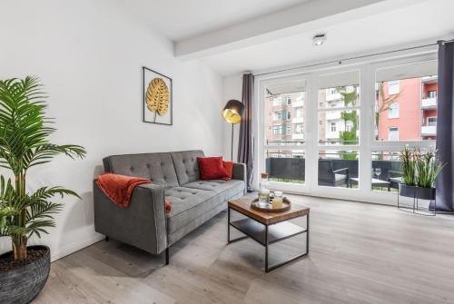 uma sala de estar com um sofá e uma mesa em CityOase im Zentrum mit 24-7 Self Check-In, WLAN & Smart TV em Kiel