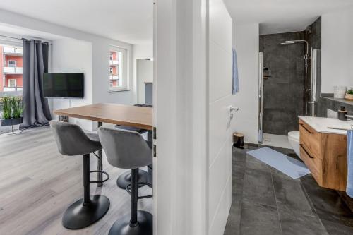 a kitchen and dining room with a wooden table and chairs at CityOase im Zentrum mit 24-7 Self Check-In, WLAN & Smart TV in Kiel