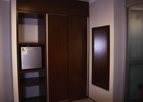 a room with a wooden closet with a mirror at OQ STANDARD HOTEL - Airport in Arequipa