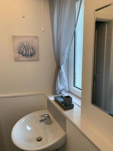 a bathroom with a sink and a mirror at Traditional Caithness Stone house in Wick