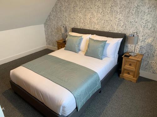 a bedroom with a large bed with blue and white pillows at Traditional Caithness Stone house in Wick