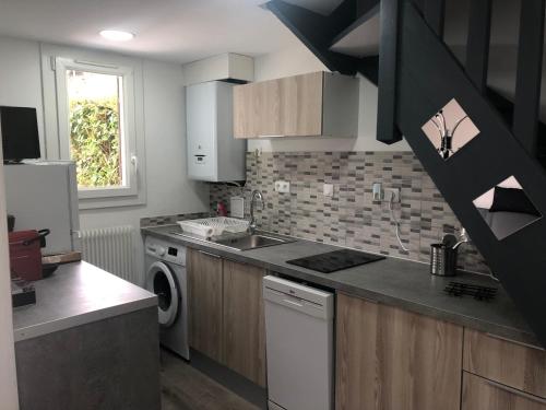 une cuisine avec un évier et un lave-vaisselle dans l'établissement Le cottage, à Villers-sur-Mer