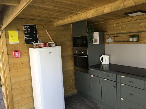 uma cozinha com um frigorífico branco num quarto em Landgoed Omorika em Ravels
