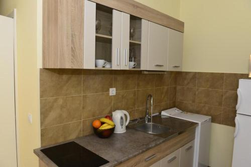 a kitchen with a sink and a counter with fruit on it at Dreams tivat in Tivat