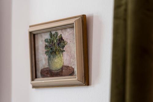 a picture of a painting of a vase on a wall at Berky Kúria - Stylish cottage in the Hills of Tolna for 16people in Nagykónyi