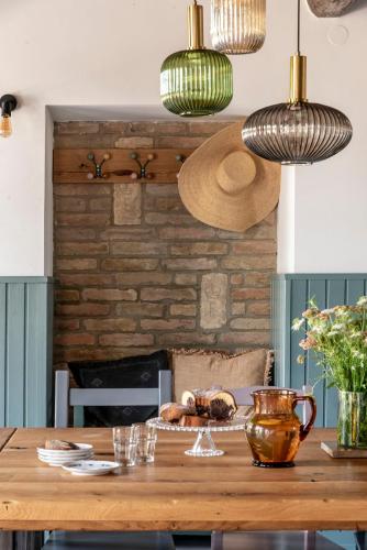 a wooden table with glasses on it with lights at Berky Kúria - Stylish cottage in the Hills of Tolna for 16people in Nagykónyi