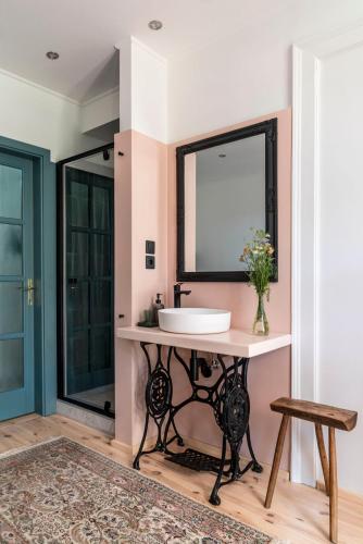 a bathroom with a sink and a mirror at Berky Kúria - Stylish cottage in the Hills of Tolna for 16people in Nagykónyi