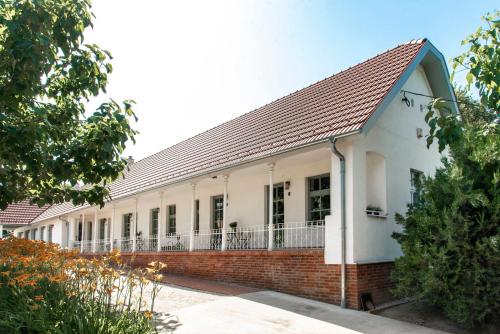 a white building with a red brick at Berky Kúria - Stylish cottage in the Hills of Tolna for 16people in Nagykónyi
