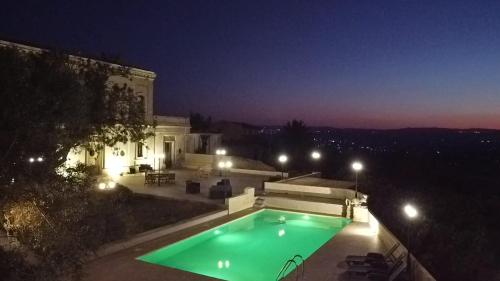 - une piscine en face d'un bâtiment la nuit dans l'établissement Casale Ciricó tra Catania e Siracusa, à Carlentini