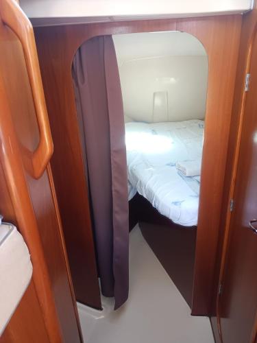 Cette petite chambre comprend un lit à l'arrière d'un bateau. dans l'établissement Nuit insolite à bord du bateau Exocet III, à Boulogne-sur-Mer