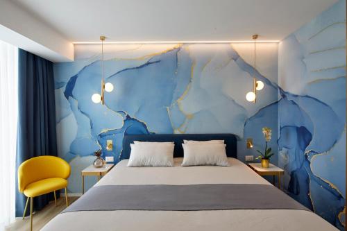 1 dormitorio con cama y pared azul en Riva Palace Hotel, en Grado