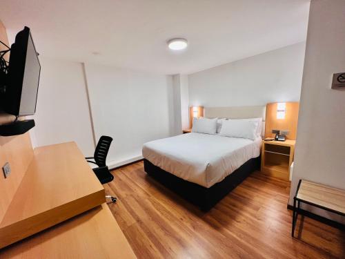 a hotel room with a bed and a desk at OQ STANDARD HOTEL - Airport in Arequipa