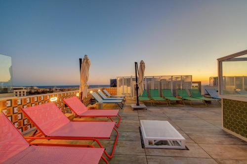 a patio with chairs and tables on a roof at IKYK Hotel- IK Collection in St Julian's