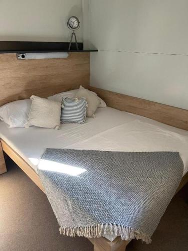 a bed with pillows on it in a room at Mobile home Privlaka in Privlaka